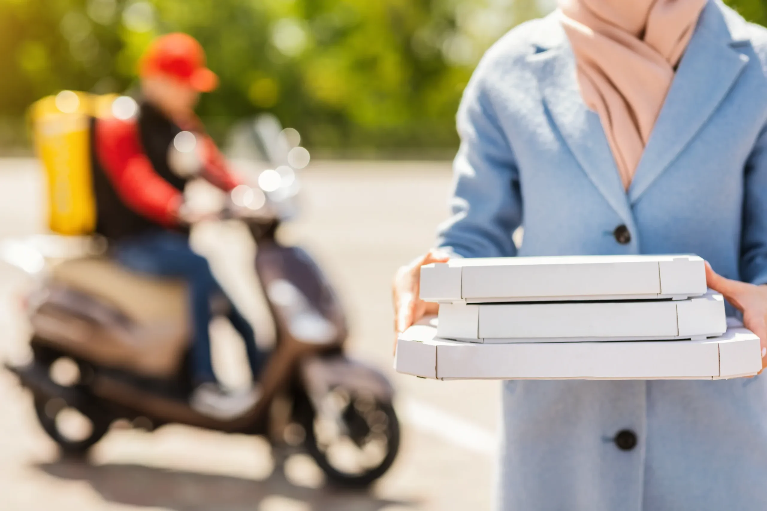 Pizza delivery service with a courier bringing pizza boxes to the customer.